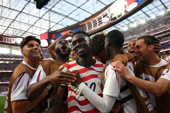 US soccer players celebrating a goal on field