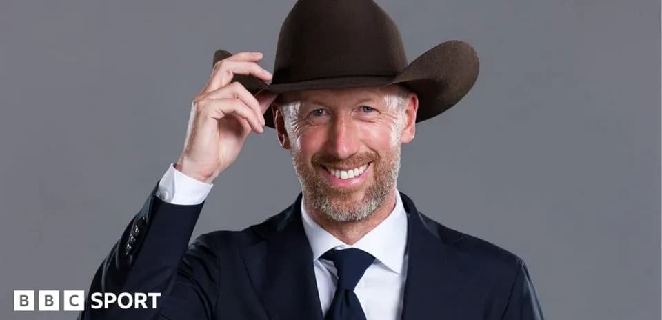 Man in suit wearing a cowboy hat and smiling