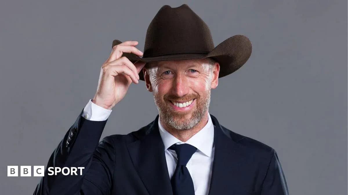Man in suit wearing a cowboy hat and smiling