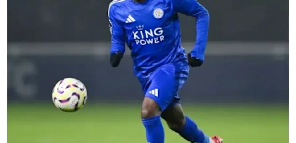 Player in blue kit dribbling ball on field