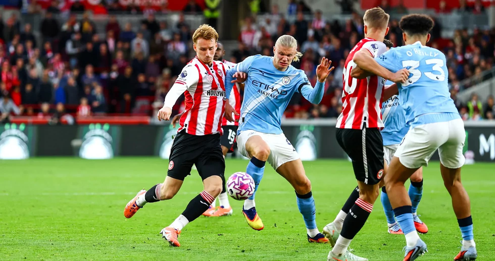 Manchester City player dribbling past Brentford defender