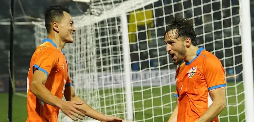 Two players celebrating a goal near the net