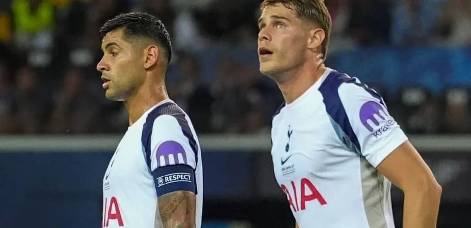 Two Tottenham players observing the game in uniform