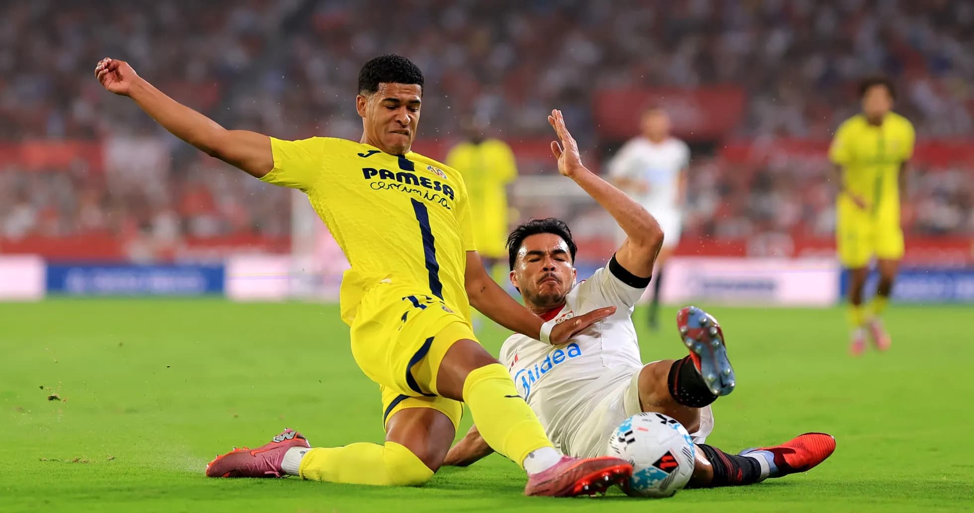 Villarreal player tackling Sevilla player on field