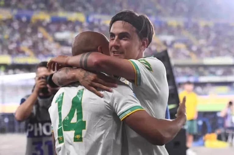Two players celebrating with an embrace on field