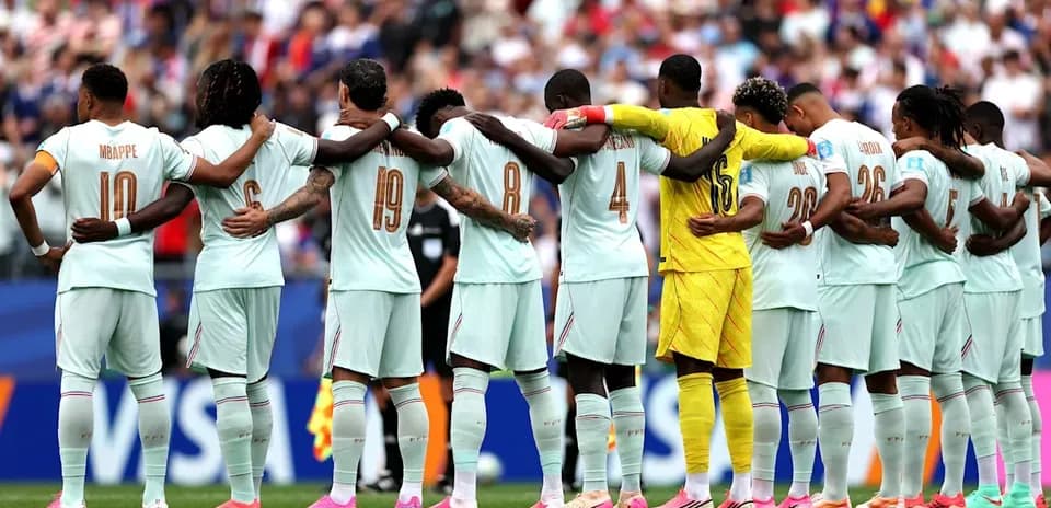 Players standing in solidarity before the match