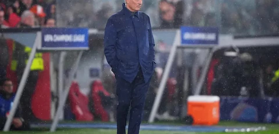 Coach observing the match in rainy conditions