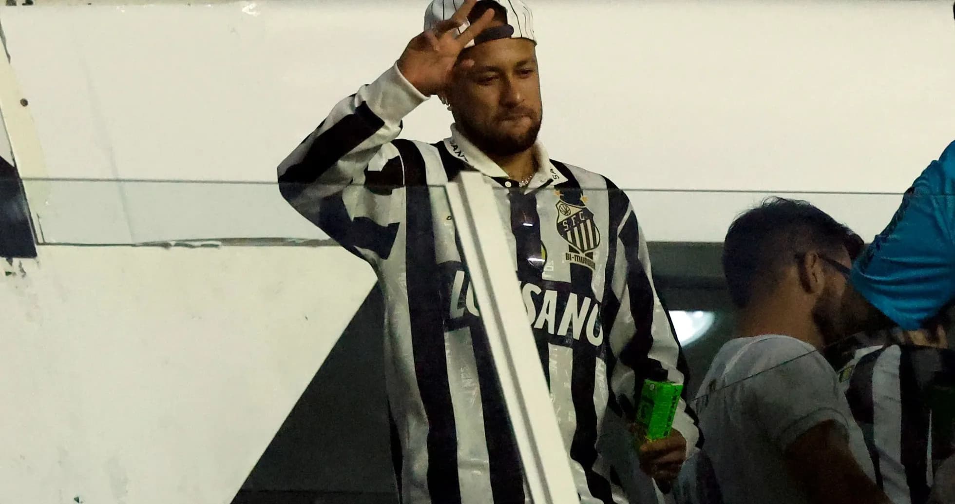 Man waving while wearing Santos FC jersey