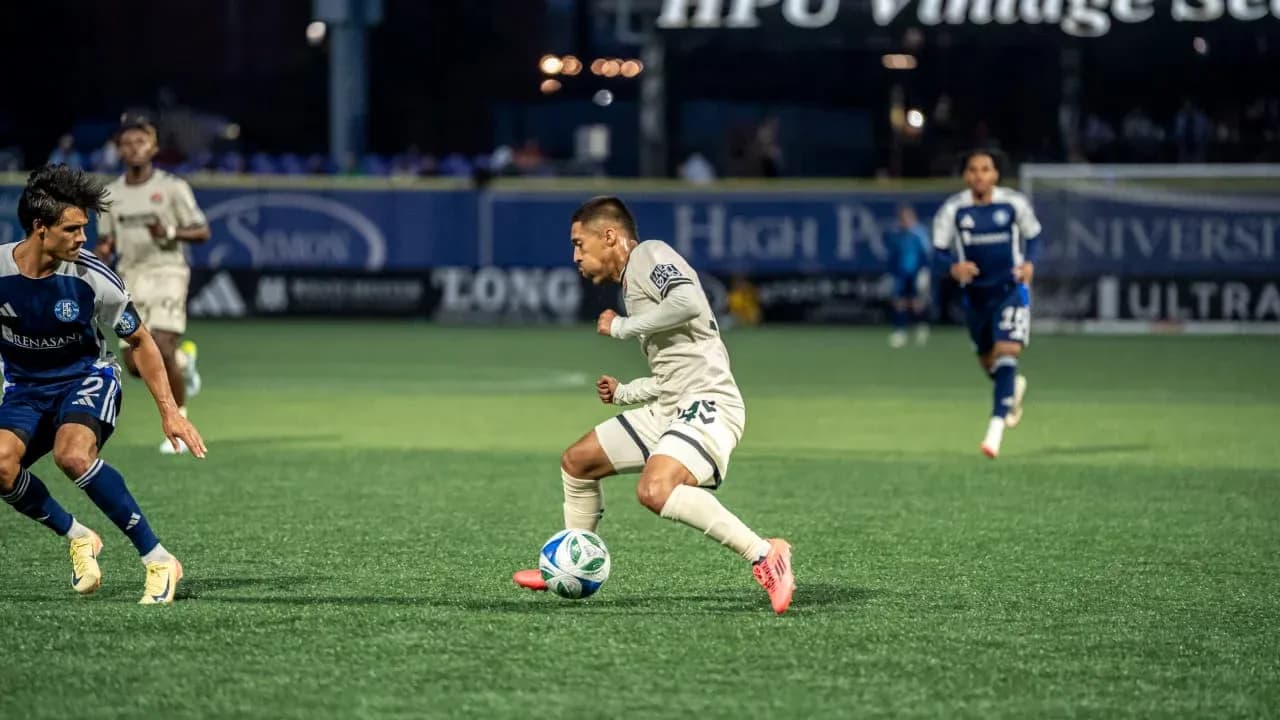 Player dribbling ball during Huntsville City match