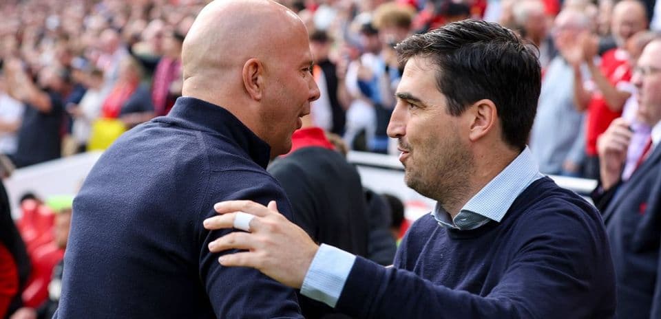 Two coaches greeting each other at the stadium