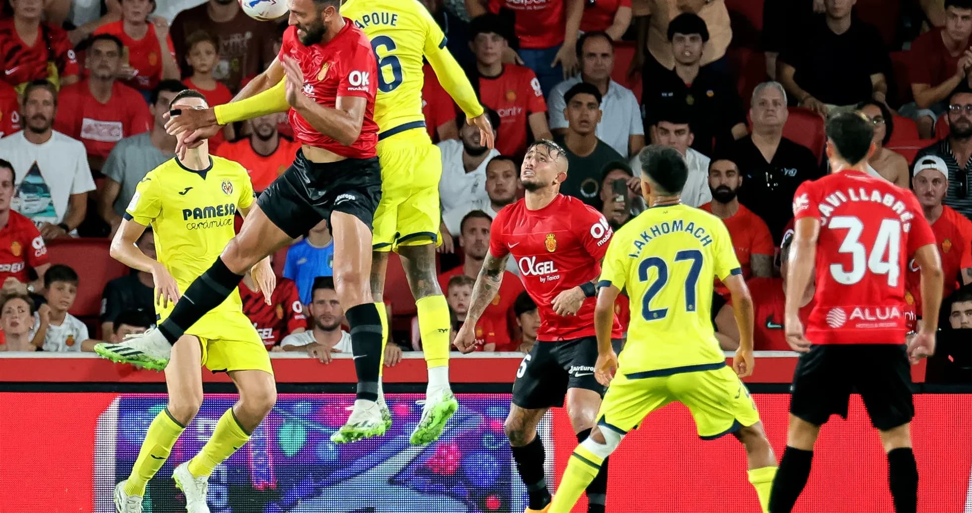 Mallorca player challenging Villarreal defender in mid-air