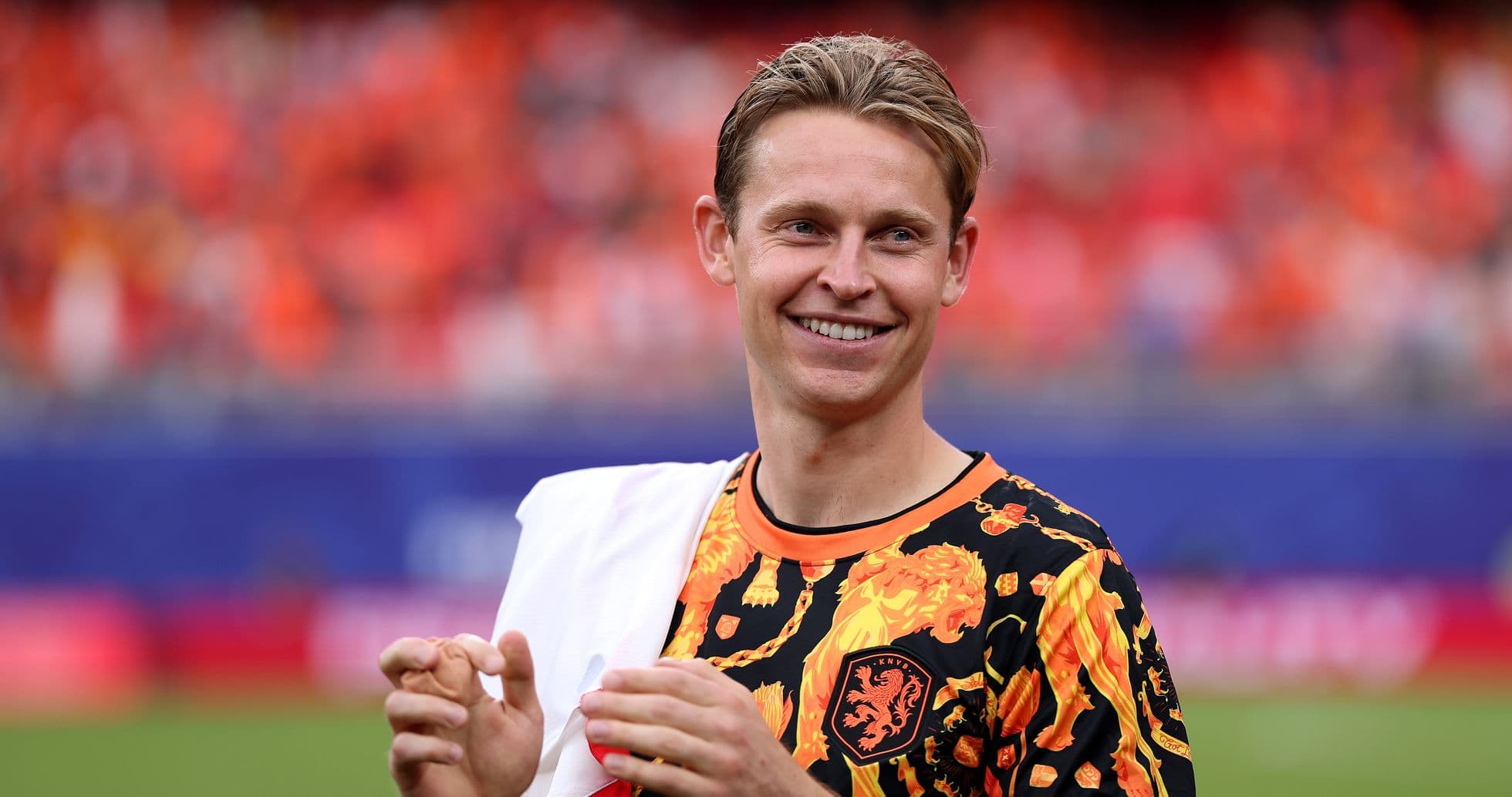 Player in vibrant shirt smiling on the field