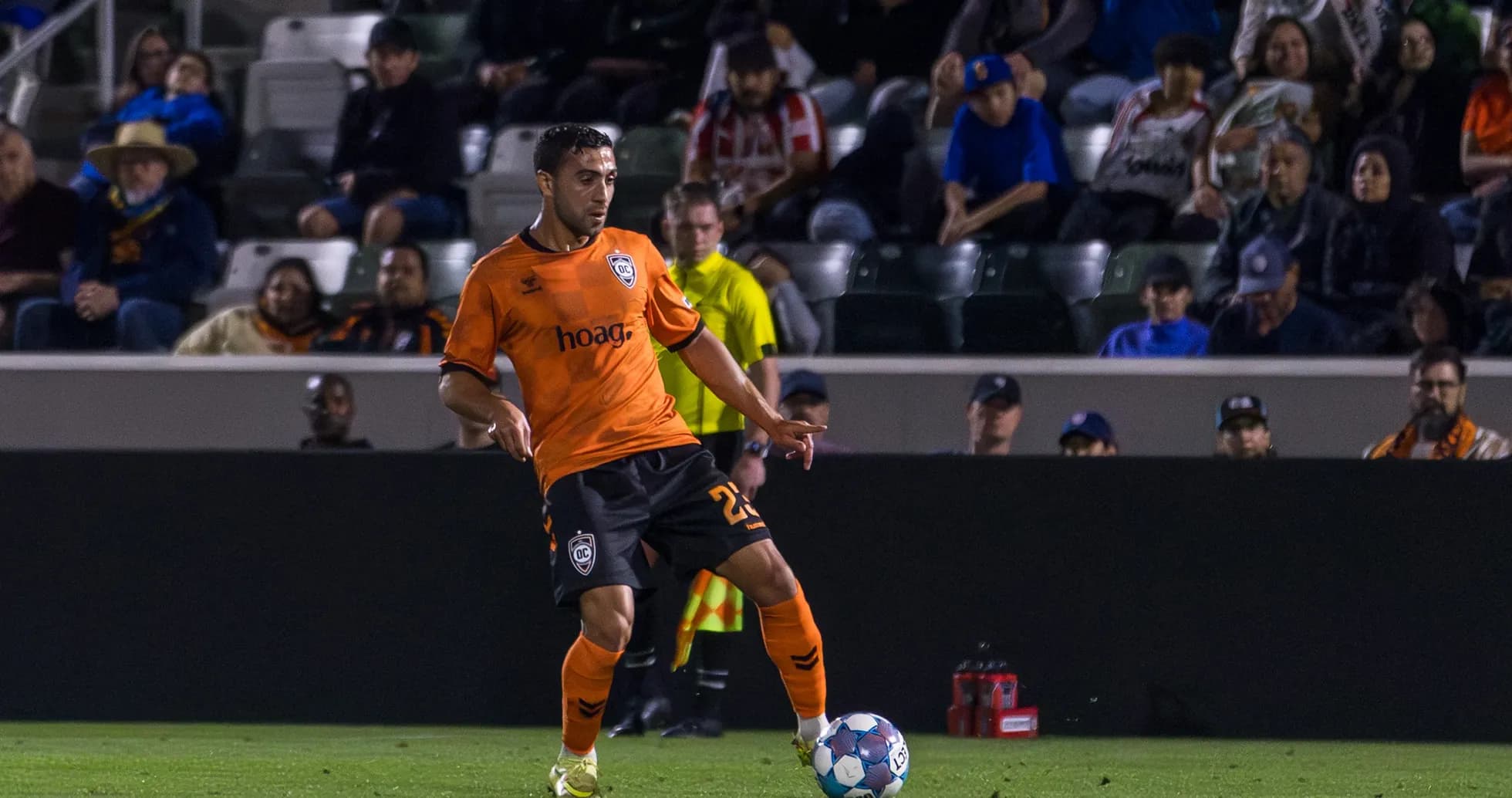 Player in orange jersey kicking the ball