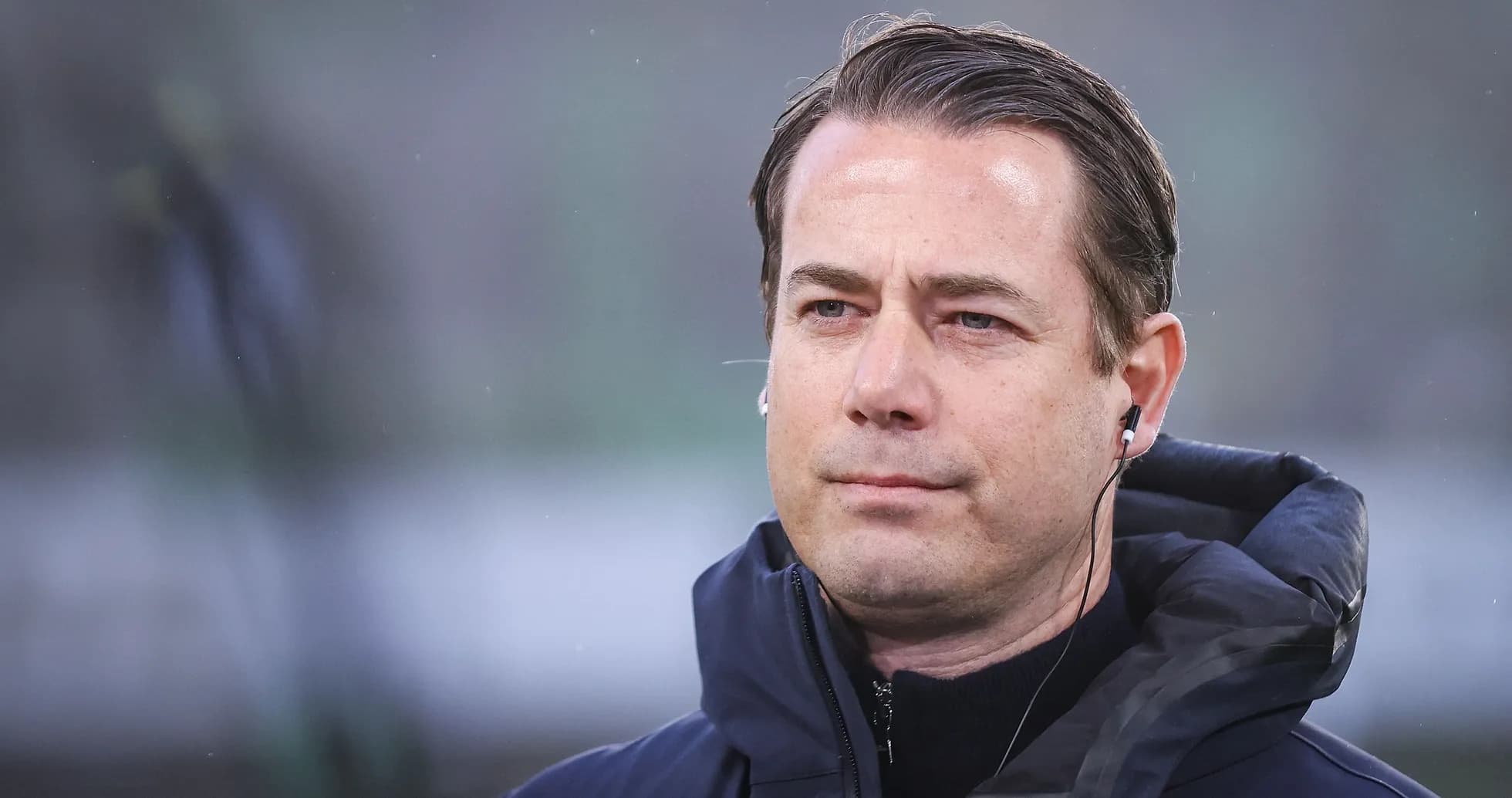 Coach wearing headphones on the sidelines