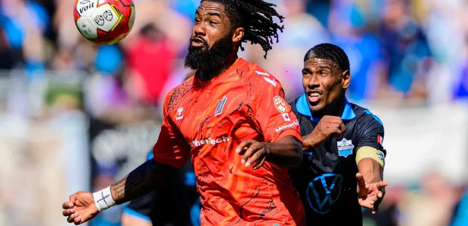 Goalkeeper and forward competing for the ball