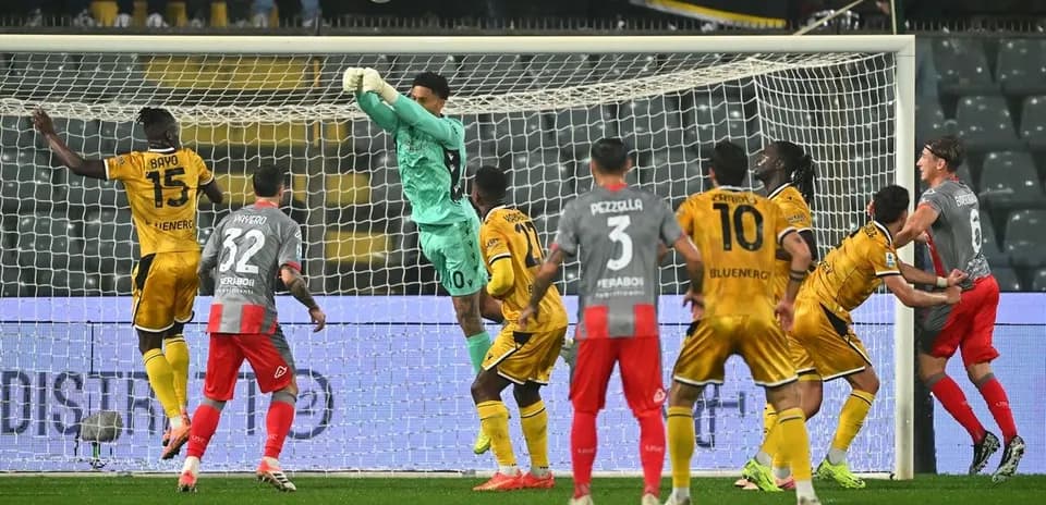 Goalkeeper saves shot during Udinese vs Cremonese match