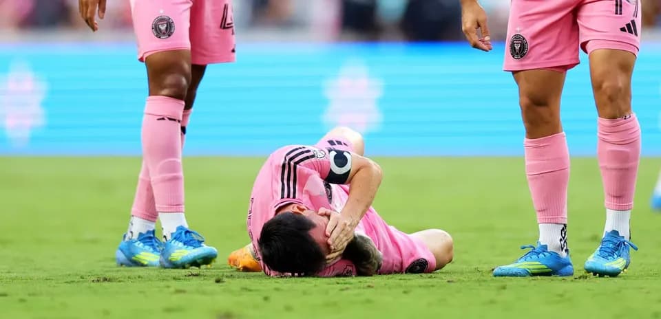 Player lying on the ground with teammates nearby