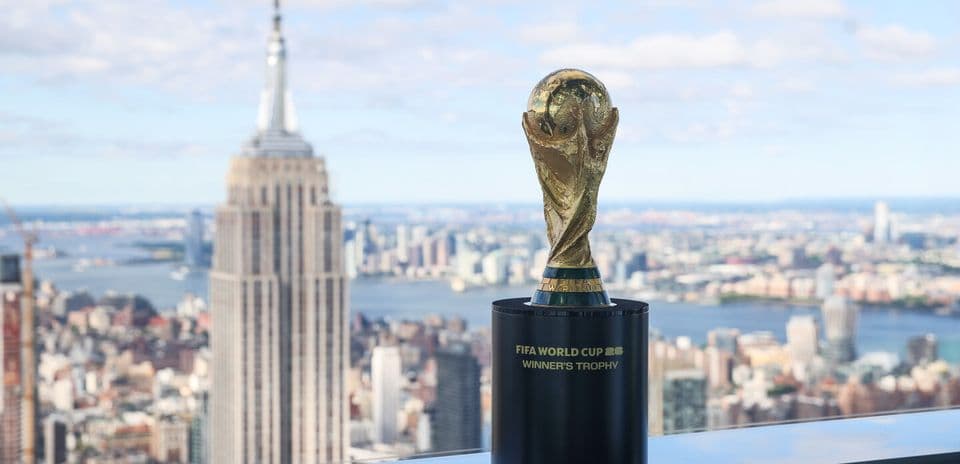 FIFA World Cup trophy displayed with city skyline