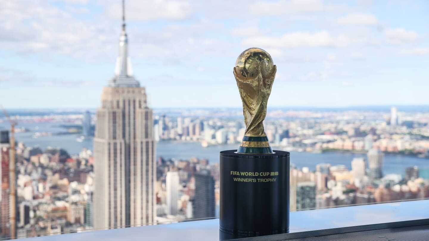 FIFA World Cup trophy displayed with city skyline
