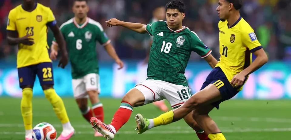 Mexico player tackling Ecuador opponent during World Cup match