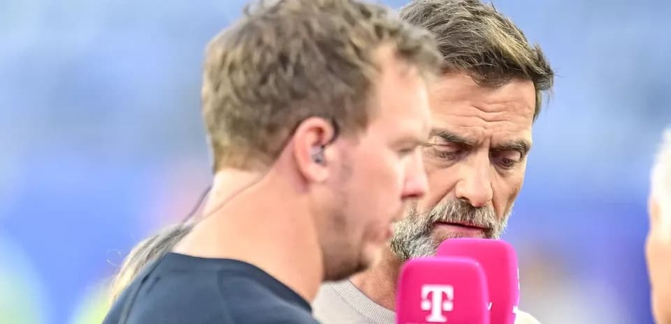 Two men speaking into microphones during an interview