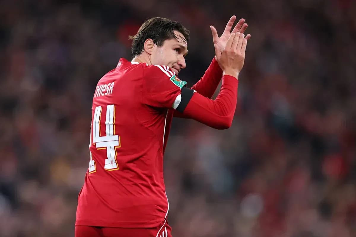 Player in red jersey applauding fans after match