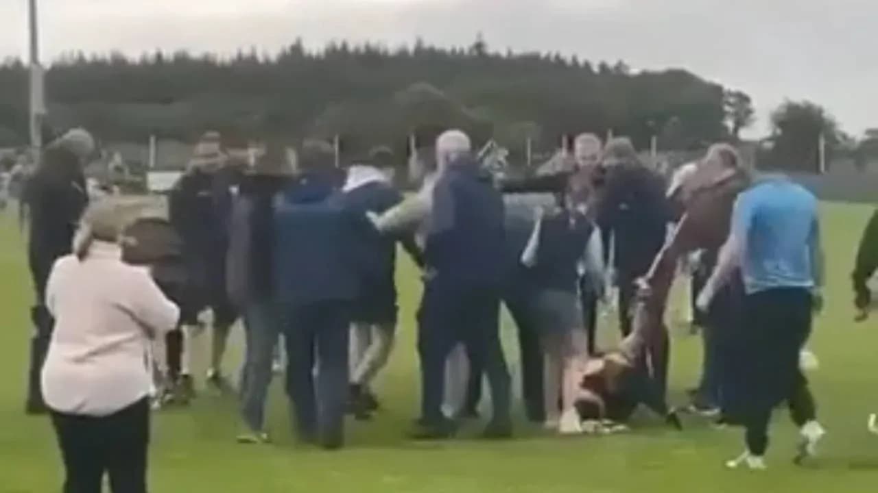 Crowd gathering around a fallen player on field