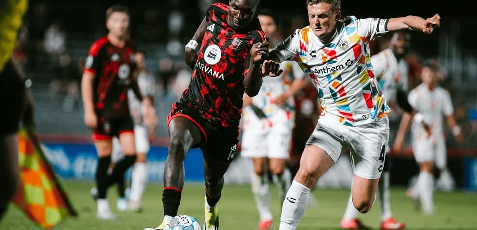 Two players competing for the ball in match