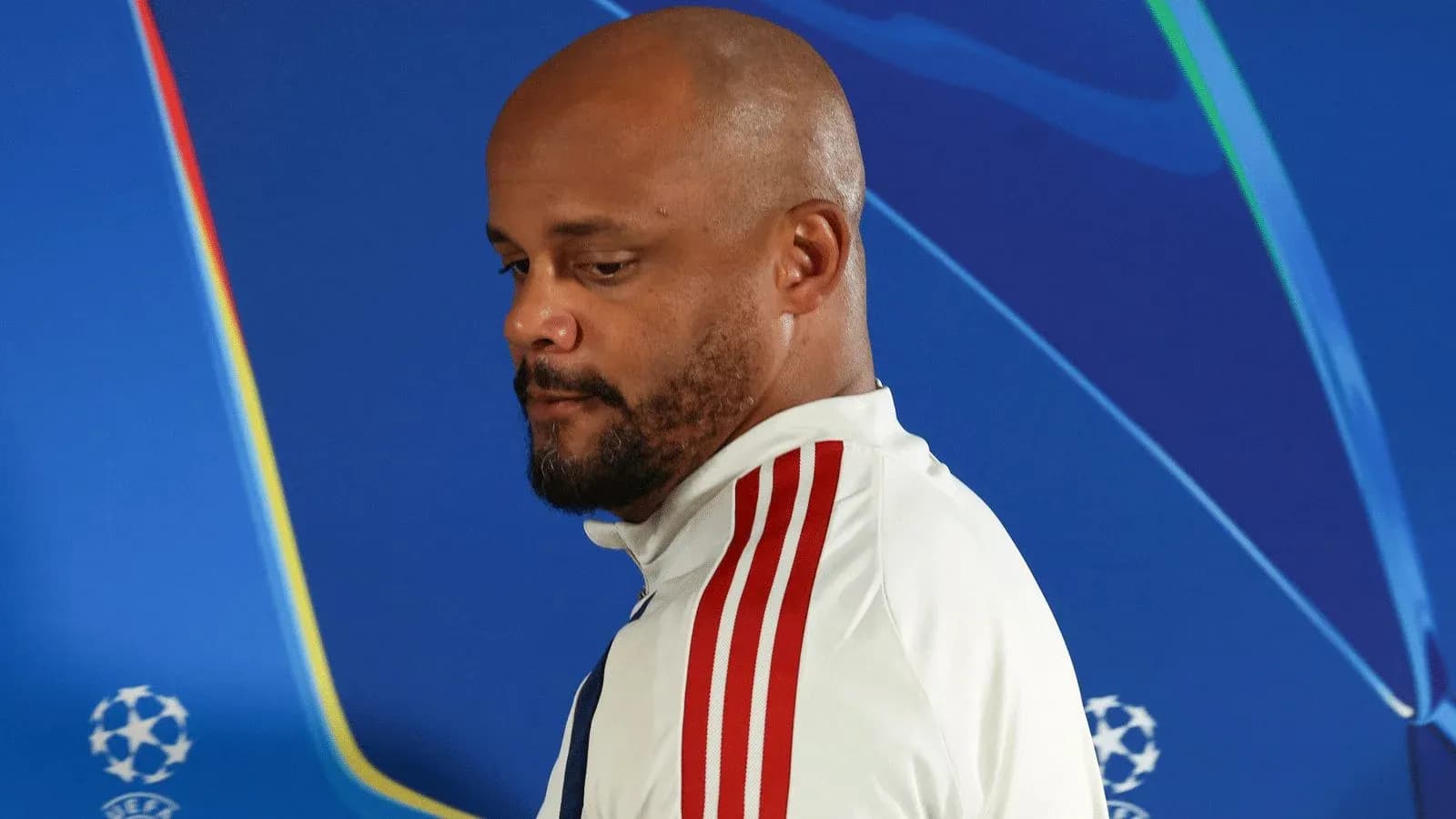 Man in sports attire during press conference backdrop