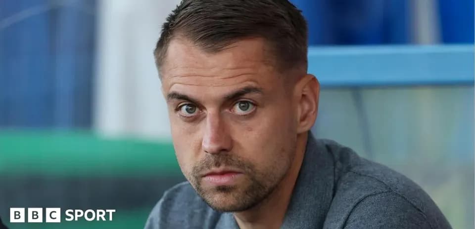 Man sitting in sports venue with serious expression