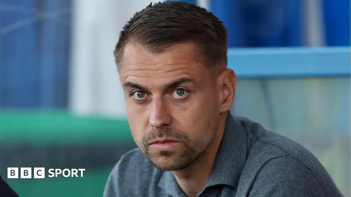Man sitting in sports venue with serious expression