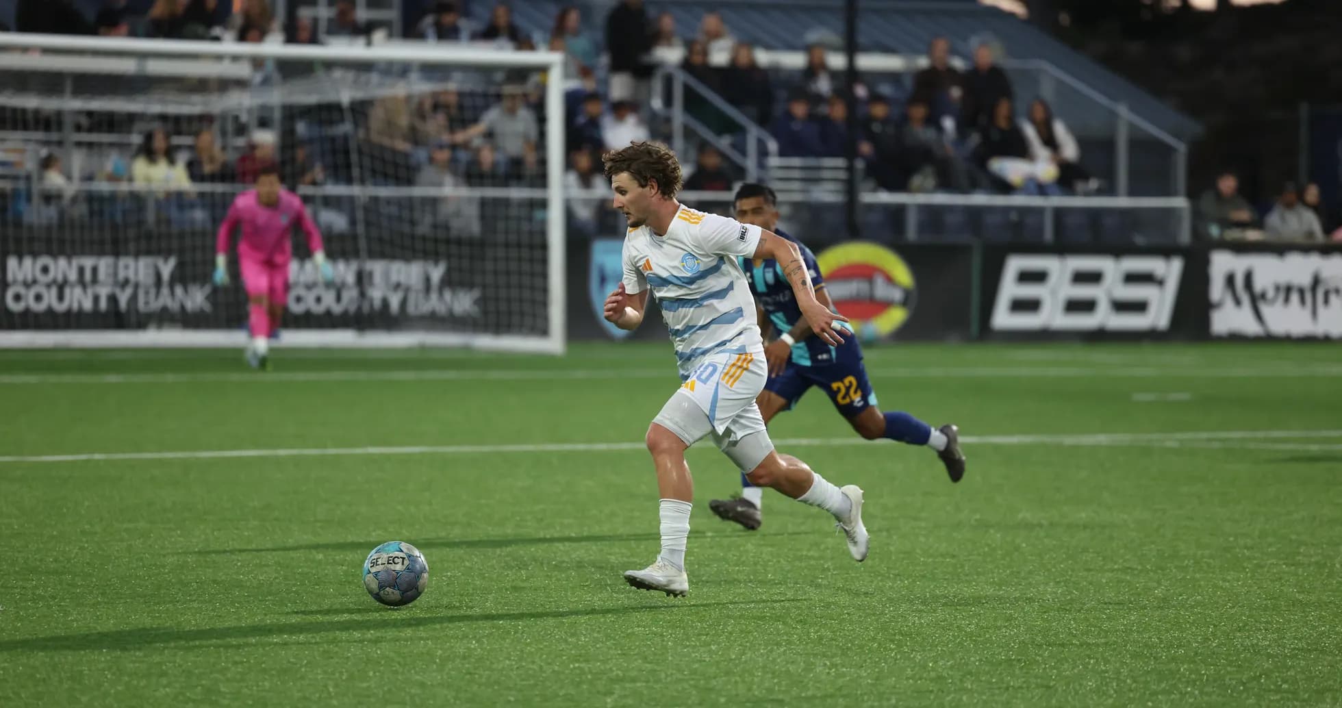 Player running with ball during Monterey Bay match