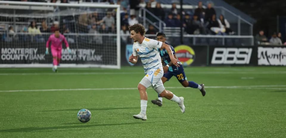 Player running with ball during Monterey Bay match