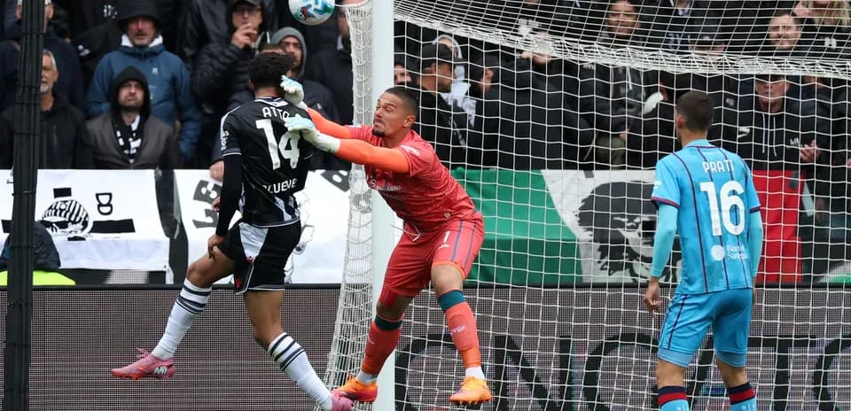 Goalkeeper challenges player during Cagliari vs Udinese match