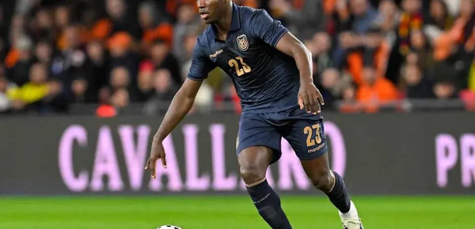 Player in dark uniform dribbling ball during match