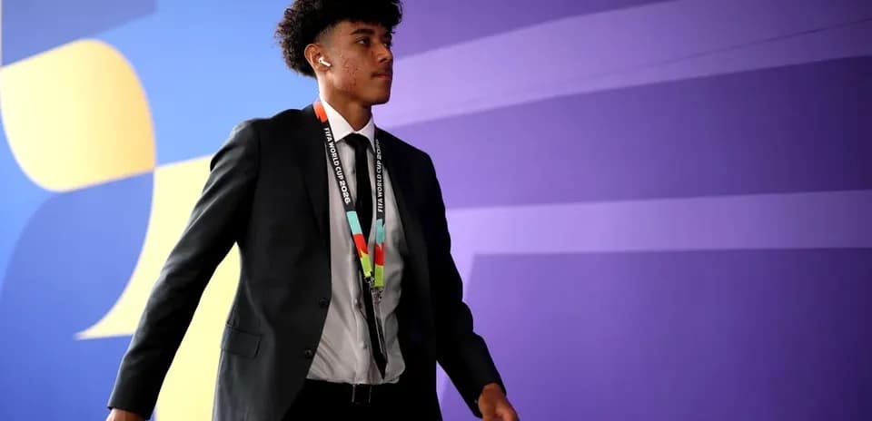 Player walking in suit with FIFA World Cup credentials