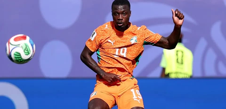 Player in orange jersey controlling the soccer ball
