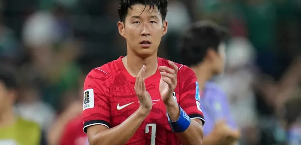 Player applauding after match wearing red jersey