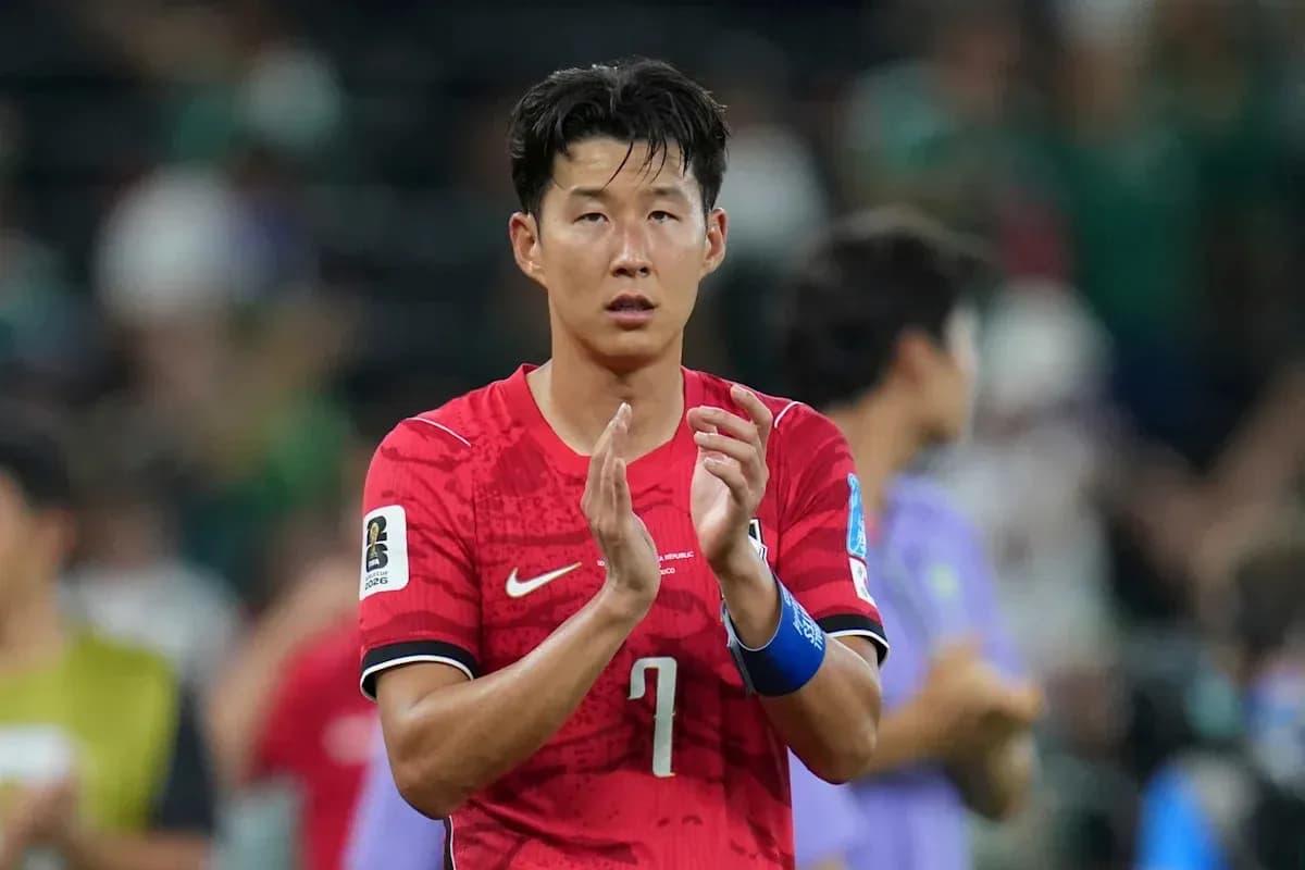 Player applauding after match wearing red jersey