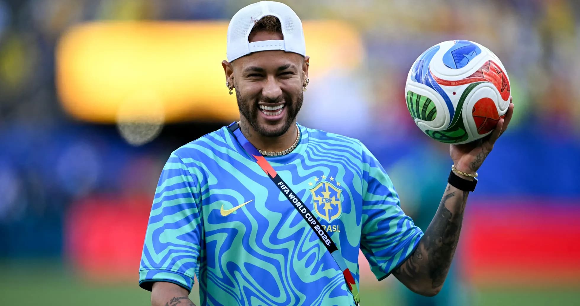 Player holding a colorful soccer ball on field