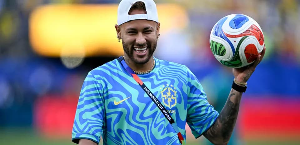 Player holding a colorful soccer ball on field