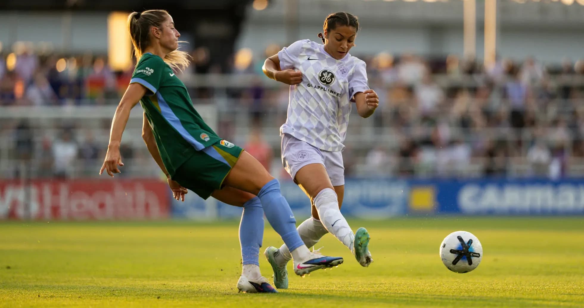 Two players competing for the ball in NWSL match