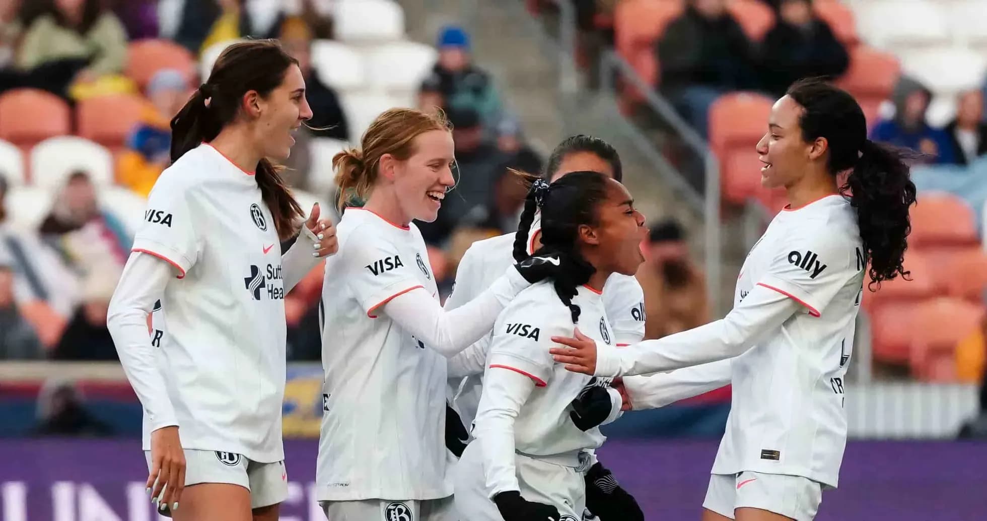 Players celebrating a goal during NWSL match