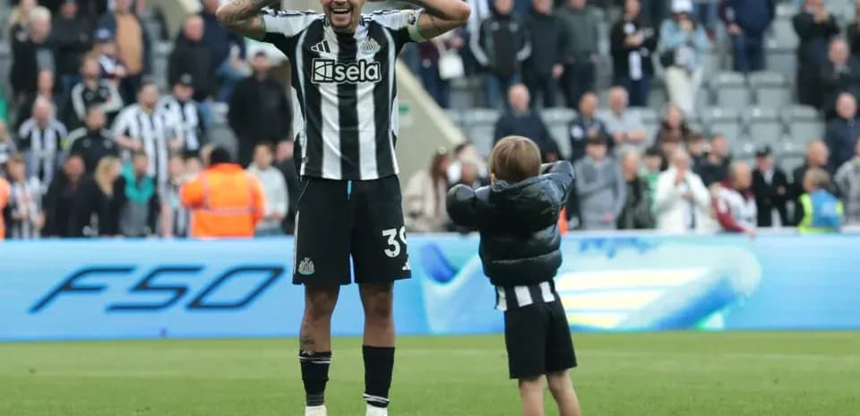 Newcastle player celebrating with young fan after match