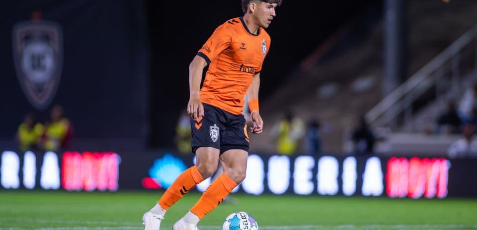 Orange County SC player dribbling ball during match