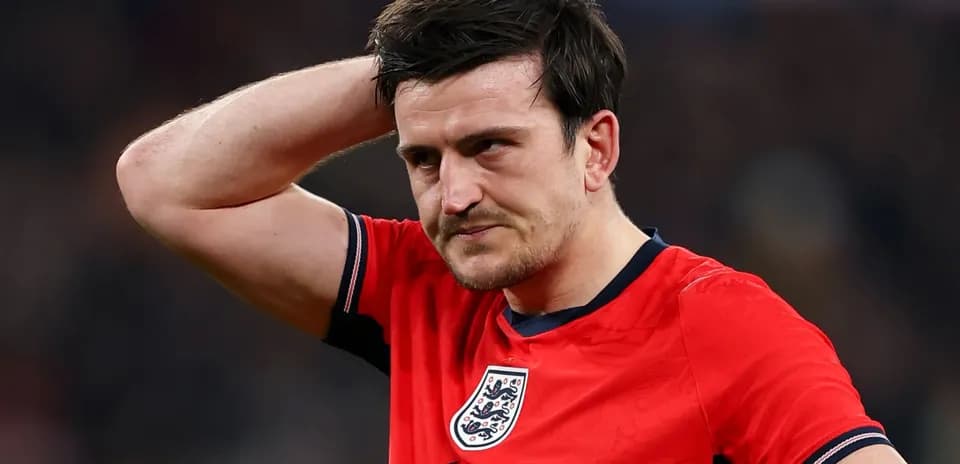 Player in red England jersey looks concerned on field