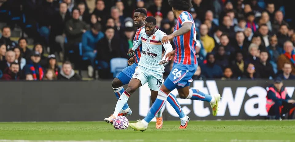 Brentford player challenged by Crystal Palace defenders