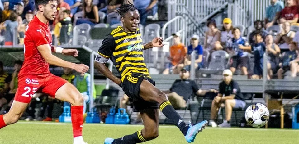 Player kicking ball during Riverhounds match