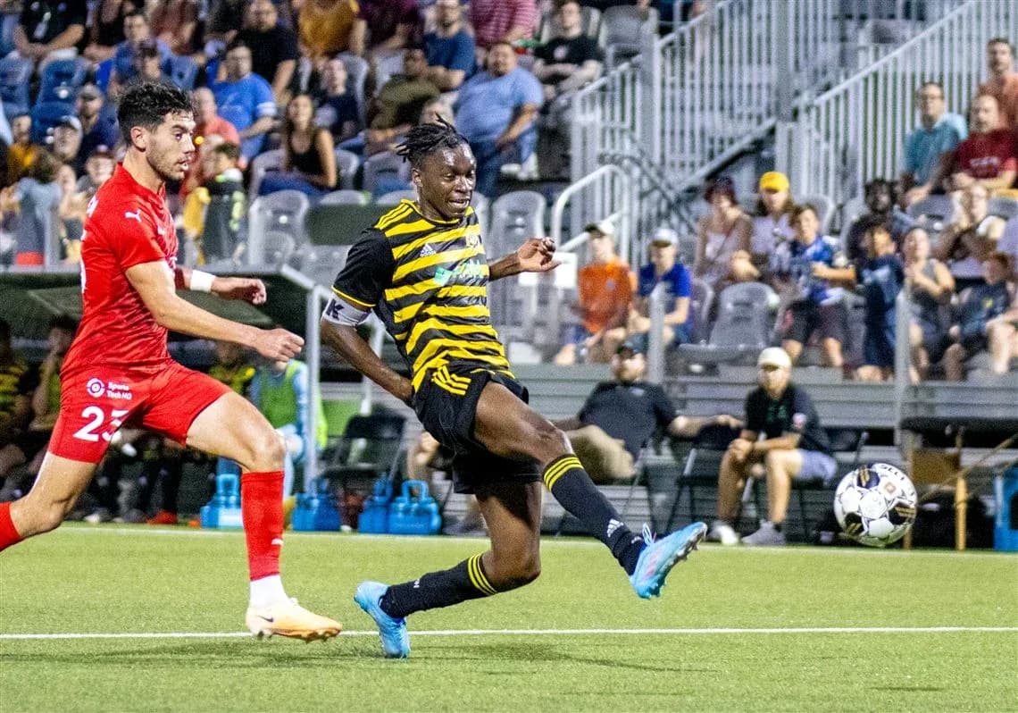 Player kicking ball during Riverhounds match