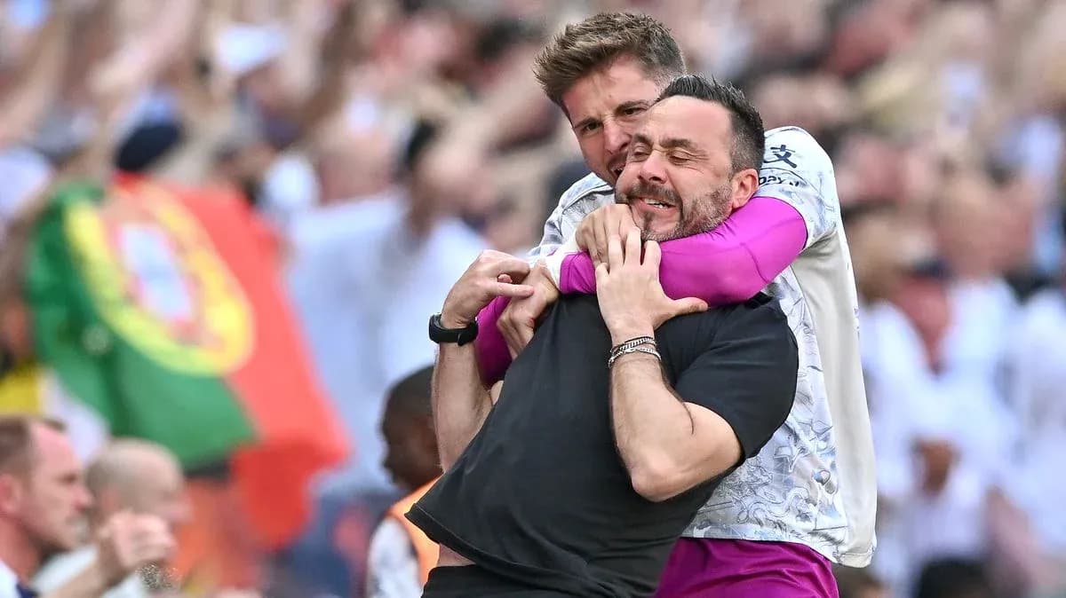 Two coaches celebrating in the stands after match